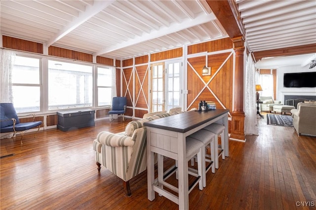 interior space with ornate columns, a fireplace, and hardwood / wood-style floors