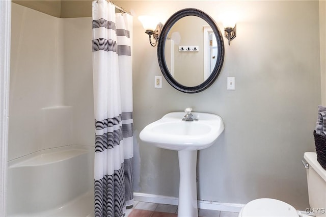 full bath with curtained shower, baseboards, and toilet