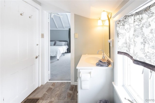 bathroom featuring connected bathroom, vanity, and wood finished floors