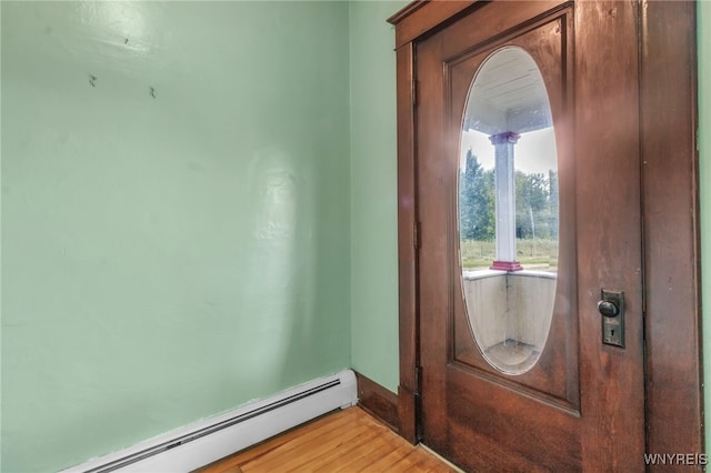 doorway featuring light wood finished floors and baseboard heating