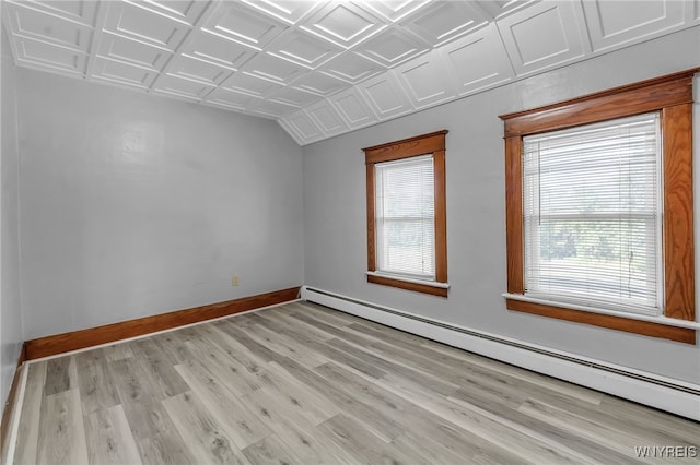 empty room with an ornate ceiling, plenty of natural light, a baseboard radiator, and baseboards