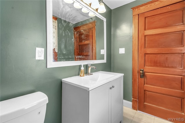 bathroom with toilet, tile patterned floors, and vanity