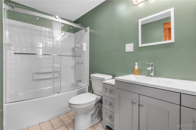 full bath featuring wood finish floors, enclosed tub / shower combo, vanity, and toilet