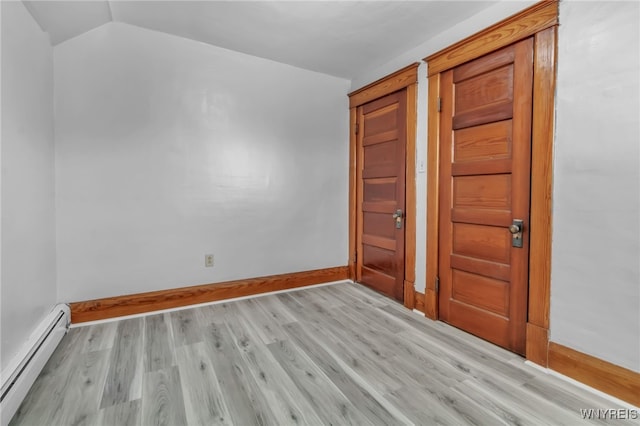 unfurnished bedroom with light wood-type flooring, vaulted ceiling, baseboards, and baseboard heating