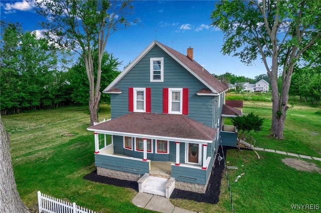 view of front of property featuring a front lawn, a chimney, and a shingled roof