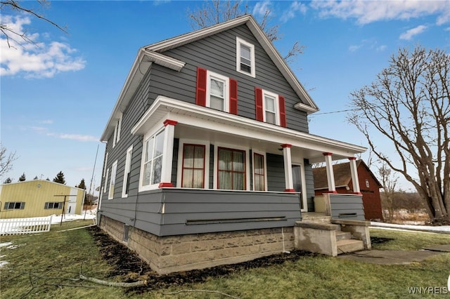 american foursquare style home with a porch and fence