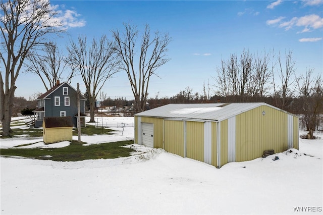 snow covered structure featuring an outbuilding