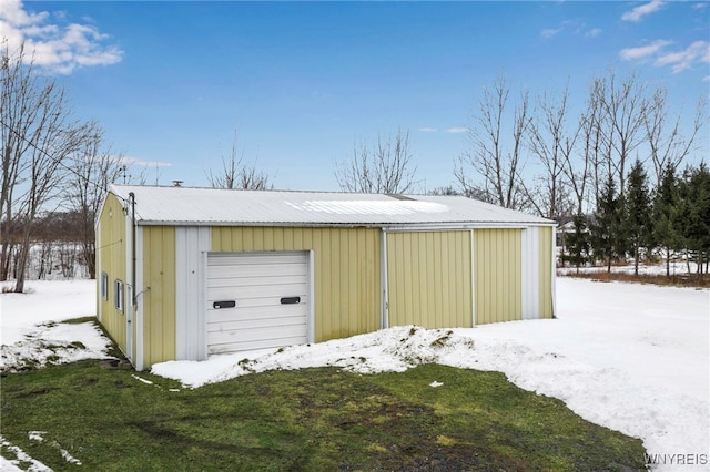 snow covered garage featuring a garage