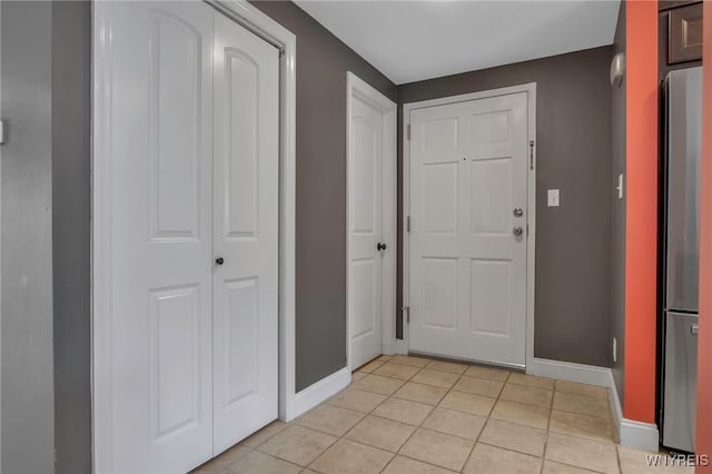 entryway with light tile patterned floors and baseboards