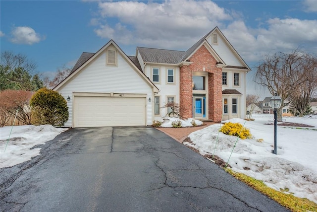 view of front of property featuring driveway, brick siding, and an attached garage