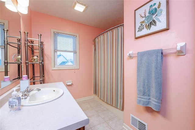 bathroom with curtained shower, visible vents, vanity, tile patterned flooring, and baseboards