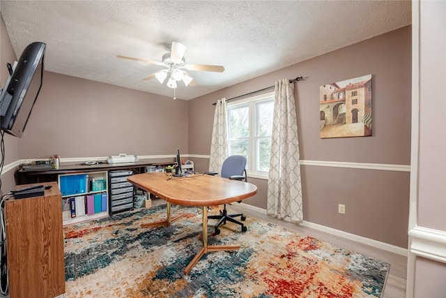 office with baseboards, a ceiling fan, and a textured ceiling