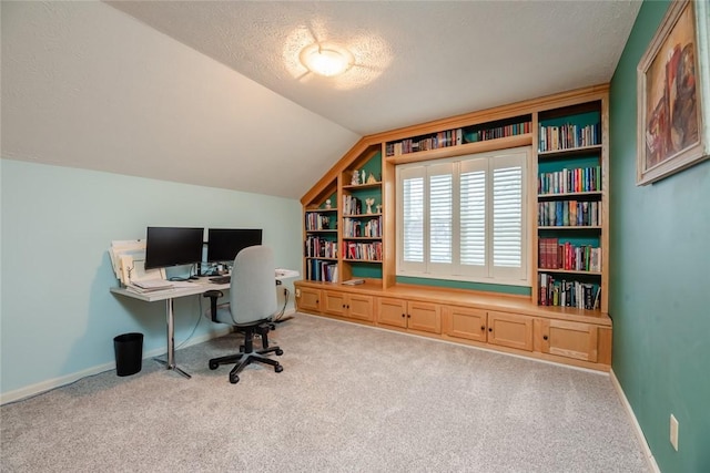 home office featuring a textured ceiling, baseboards, vaulted ceiling, and carpet flooring