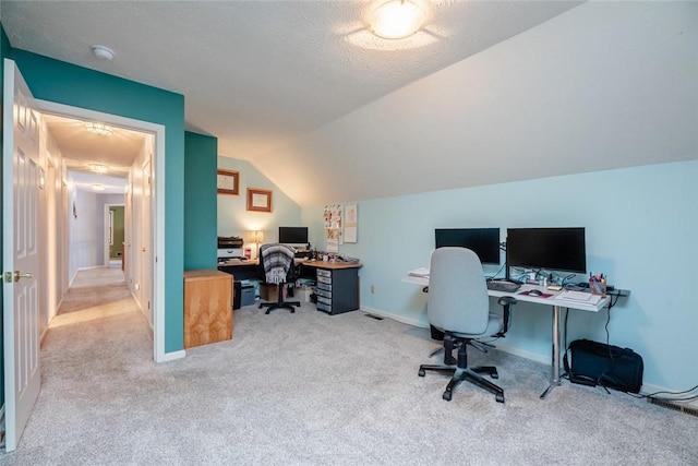 office area with lofted ceiling, carpet flooring, a textured ceiling, and baseboards