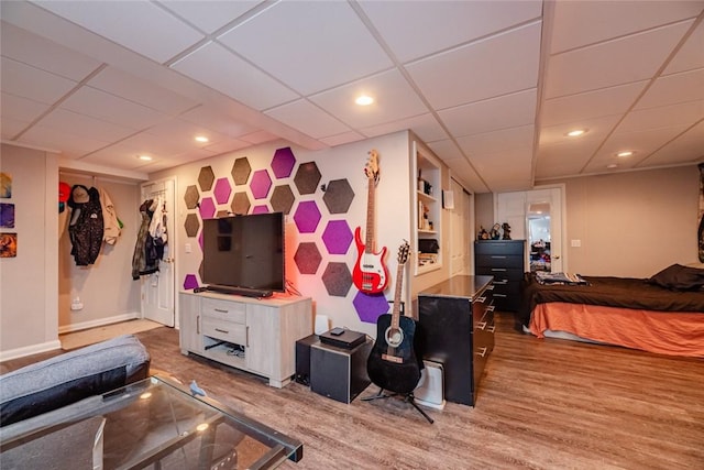 interior space with baseboards, a drop ceiling, wood finished floors, and recessed lighting