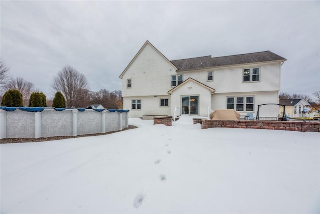 snow covered property featuring a covered pool