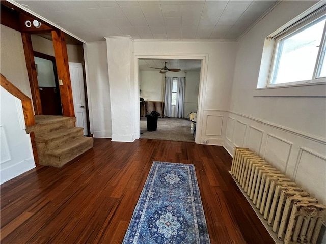 hallway with stairs, a wealth of natural light, crown molding, and hardwood / wood-style flooring