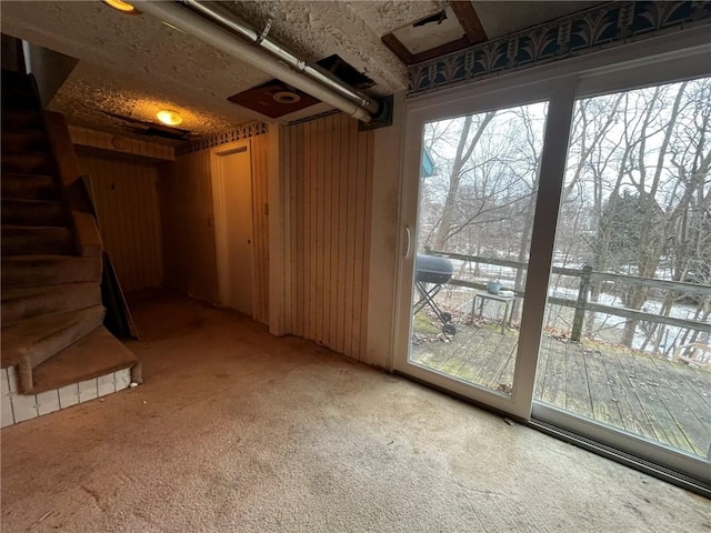 below grade area with light carpet, stairway, and a wealth of natural light