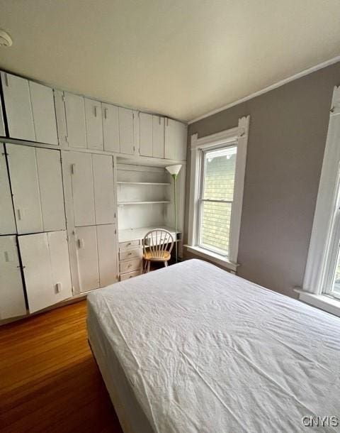 bedroom featuring dark wood-style flooring and crown molding