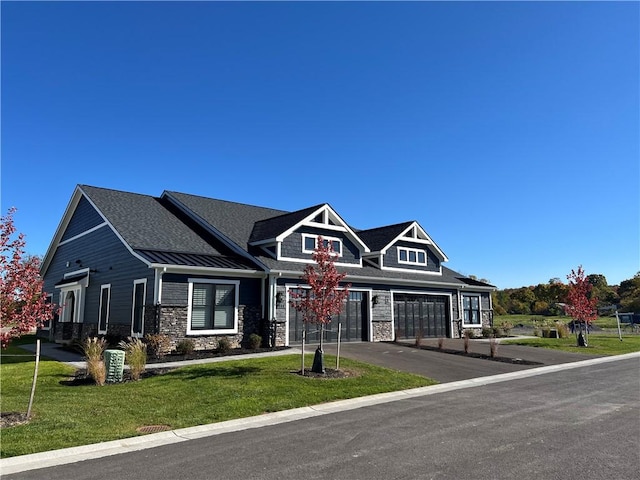 craftsman house with driveway, stone siding, metal roof, a standing seam roof, and a front yard