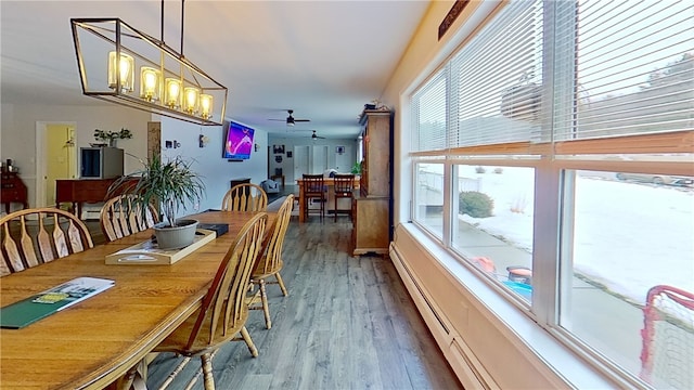 dining room featuring a baseboard radiator, wood finished floors, and a ceiling fan