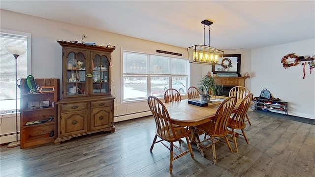 dining room featuring baseboard heating, a fireplace, and dark wood finished floors