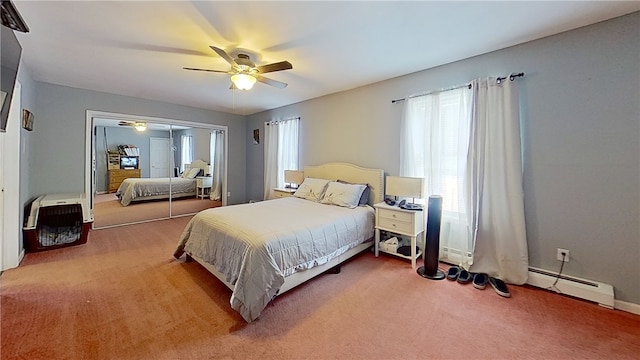 carpeted bedroom featuring a baseboard heating unit and a ceiling fan