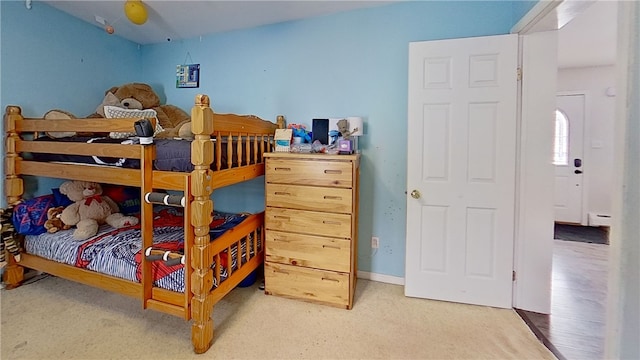 bedroom with a baseboard heating unit, carpet floors, and baseboards