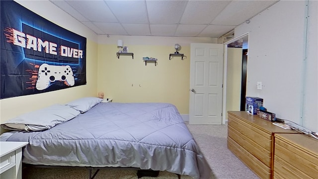 carpeted bedroom featuring a drop ceiling