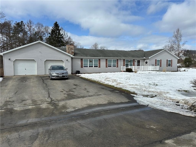 ranch-style house with a porch, driveway, a chimney, and an attached garage