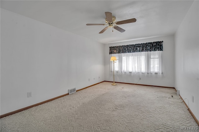 unfurnished room featuring a ceiling fan, carpet, visible vents, and baseboards