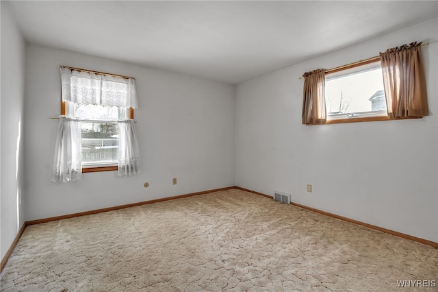 unfurnished room with carpet floors, baseboards, and visible vents