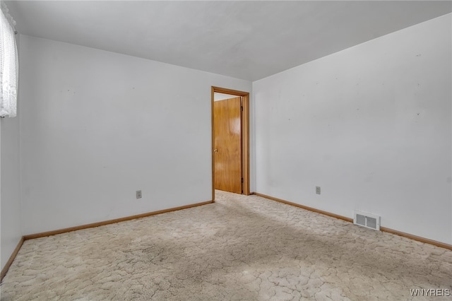 carpeted empty room featuring visible vents and baseboards