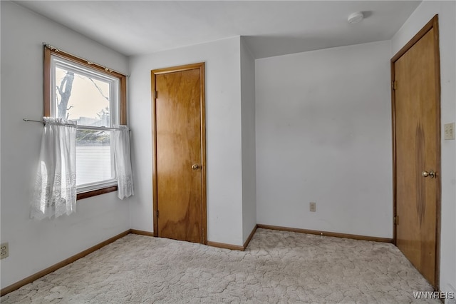 unfurnished bedroom featuring carpet and baseboards