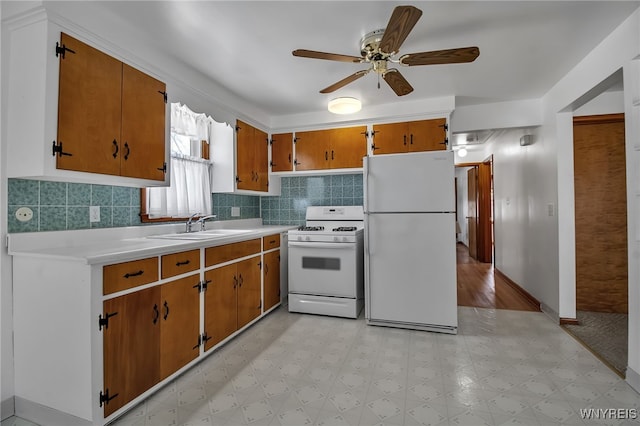 kitchen featuring light countertops, white appliances, light floors, and a sink