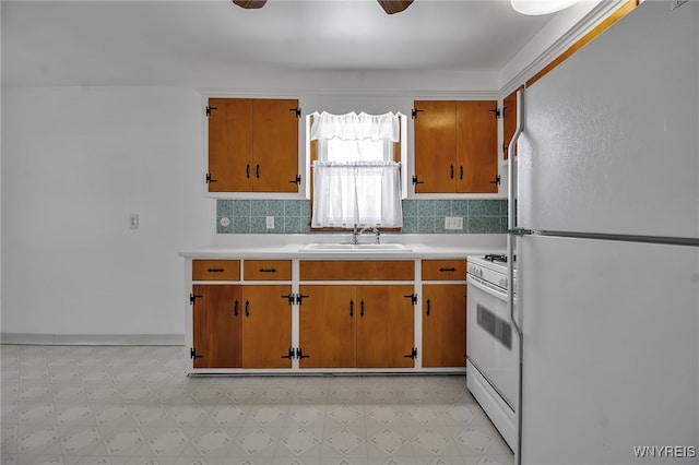 kitchen with white appliances, light floors, a sink, and light countertops