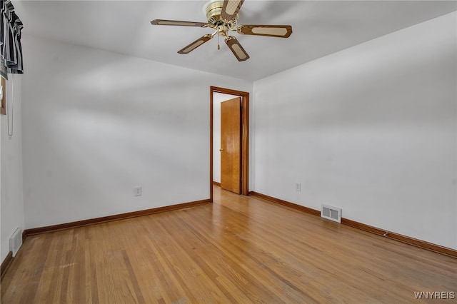 spare room with light wood-type flooring, baseboards, visible vents, and ceiling fan