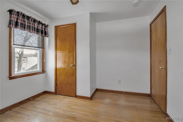 unfurnished bedroom with baseboards and light wood-style floors