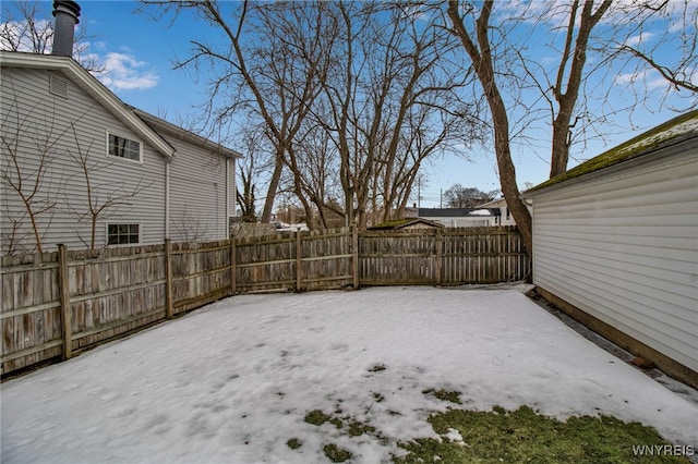 yard covered in snow featuring fence