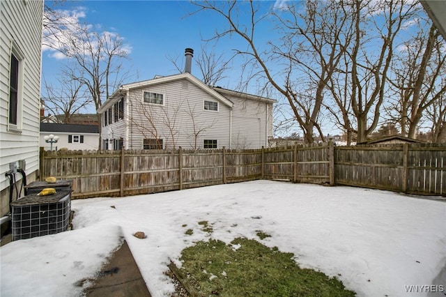 yard covered in snow with central AC unit and a fenced backyard