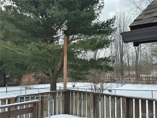 yard covered in snow featuring fence