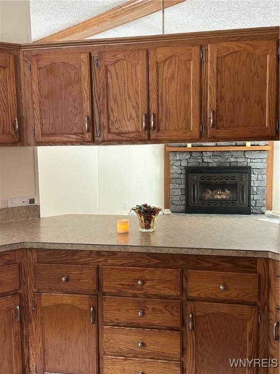 kitchen with a fireplace and brown cabinets