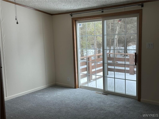 doorway with carpet floors, visible vents, ornamental molding, and a textured ceiling