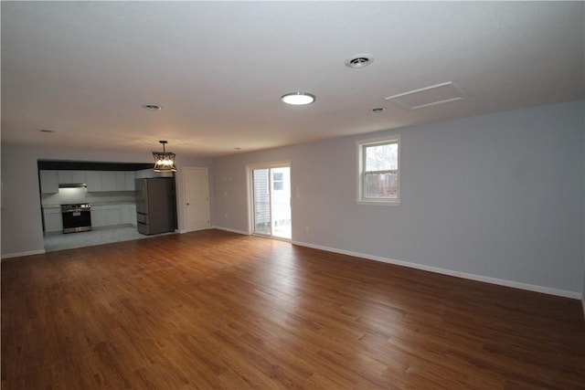 unfurnished living room featuring wood finished floors and baseboards