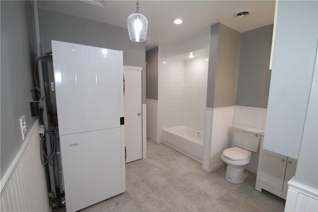 full bathroom with visible vents, shower / washtub combination, wainscoting, and toilet