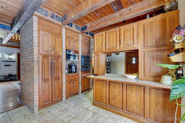 kitchen featuring light tile patterned floors, brown cabinets, and beamed ceiling