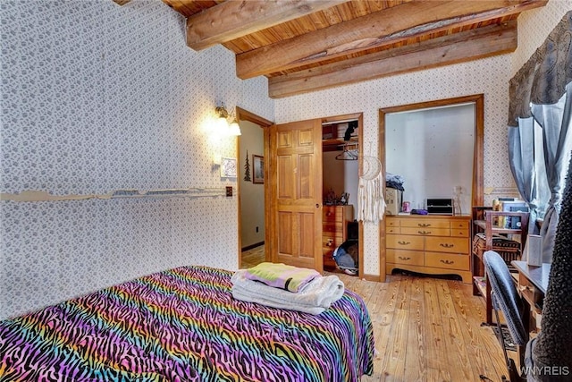 bedroom featuring wallpapered walls, wood ceiling, beamed ceiling, light wood-type flooring, and a closet