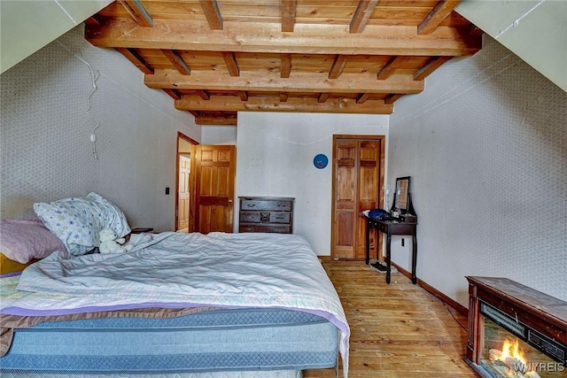 bedroom with hardwood / wood-style floors, beamed ceiling, and wood ceiling