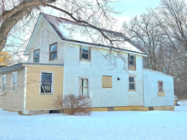 view of snow covered back of property