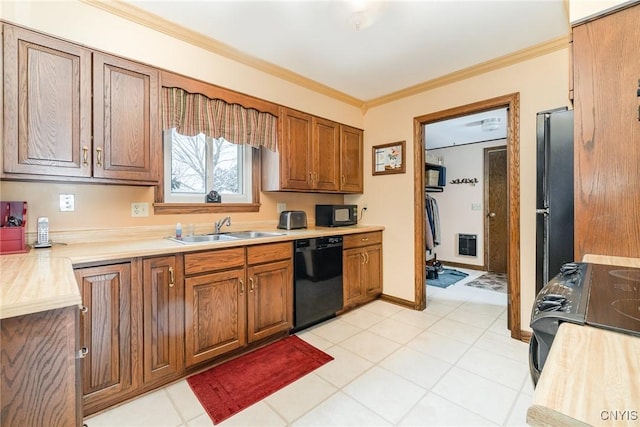 kitchen with light countertops, brown cabinetry, ornamental molding, a sink, and black appliances